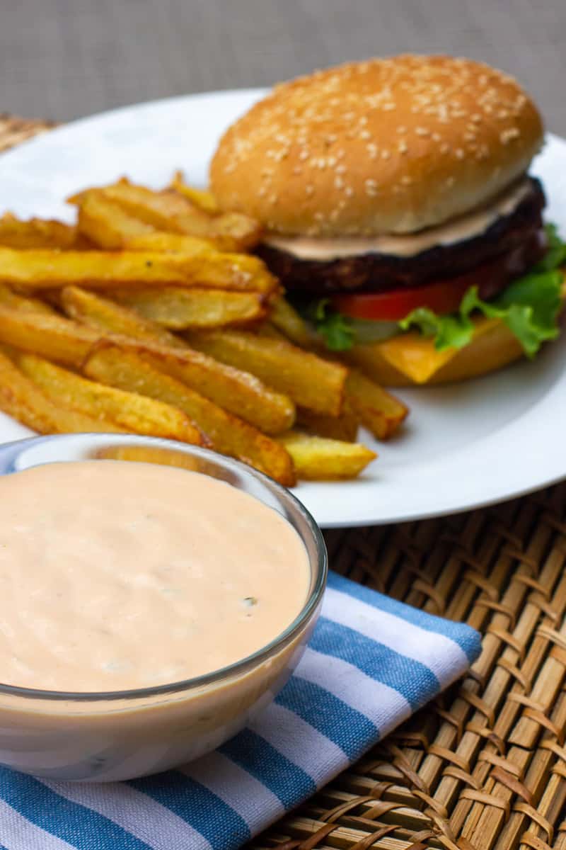 A bowl of Big Mac secret sauce with a burger and fries.