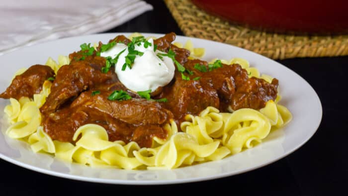 Beef pasta dish on a white plate.