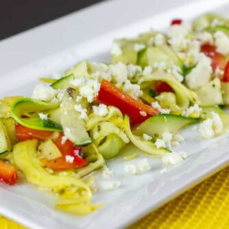 A close up of a salad made with zucchini and yellow squash.