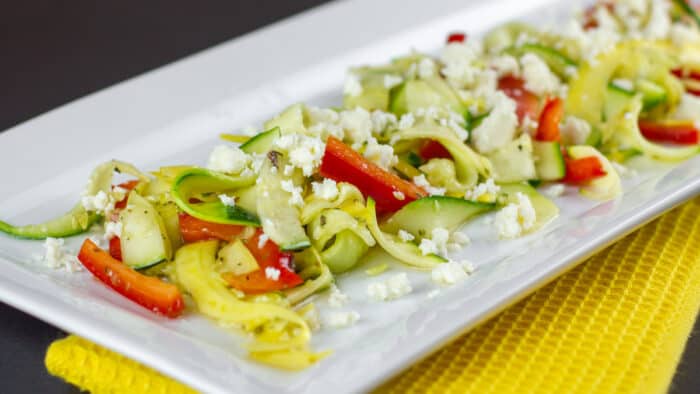 A close up of a salad made with zucchini and yellow squash.