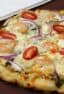 How to cook a pizza on a grill with this great BBQ pizza recipe, made with shrimp, pesto, red onions, grape tomatoes, feta cheese and mozzarella.