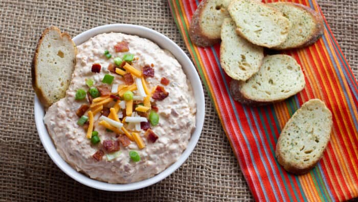 Overhead picture of a bowl of dip with toasted baguettes