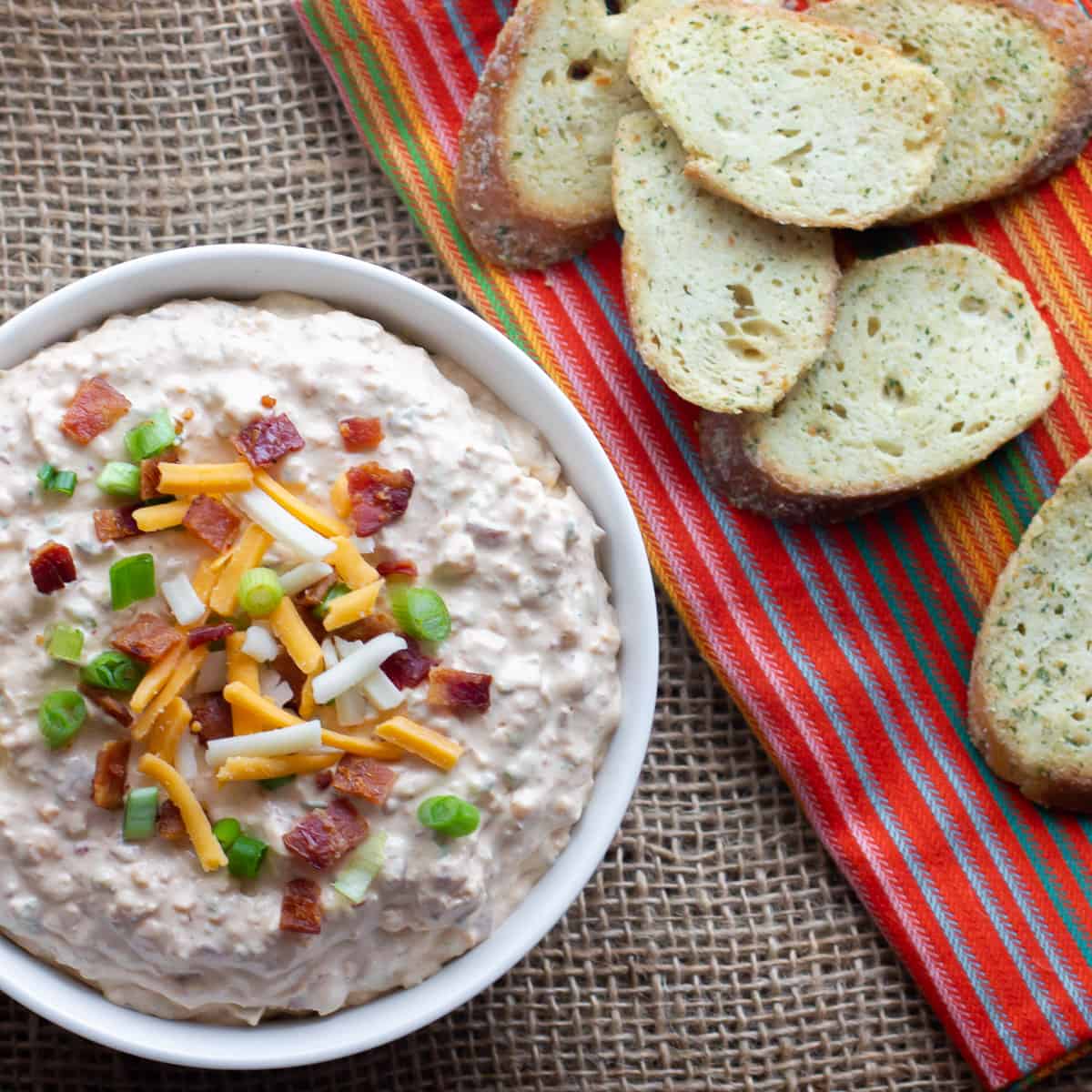 Overhead picture of a bowl of dip with toasted baguettes