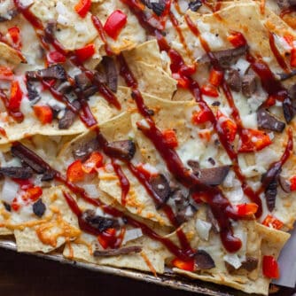Nachos made with smoked brisket, provolone cheese, onions, peppers baked on tortilla chips with BBQ sauce. Simple party food that is smokey and delicious!