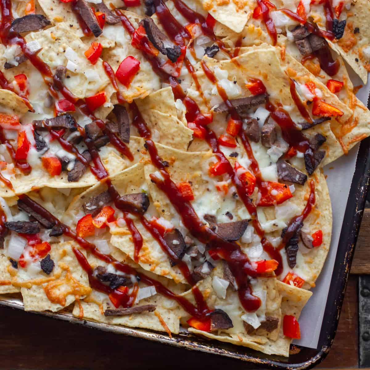 Smoked Brisket, provolone cheese, onions, peppers baked on tortilla chips with BBQ sauce. This simple party food is smokey and delicious! Or use leftover steak