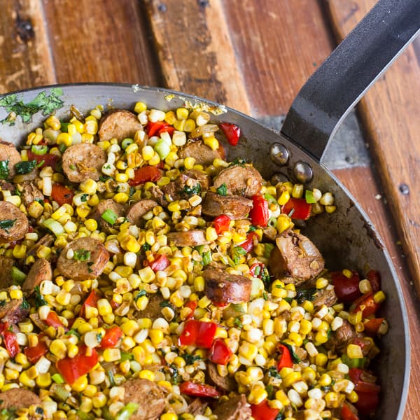 fried corn in a skillet with sausage