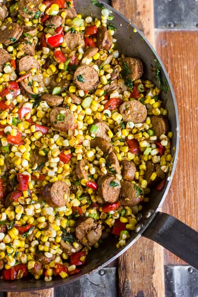 fried corn in a skillet with sausage