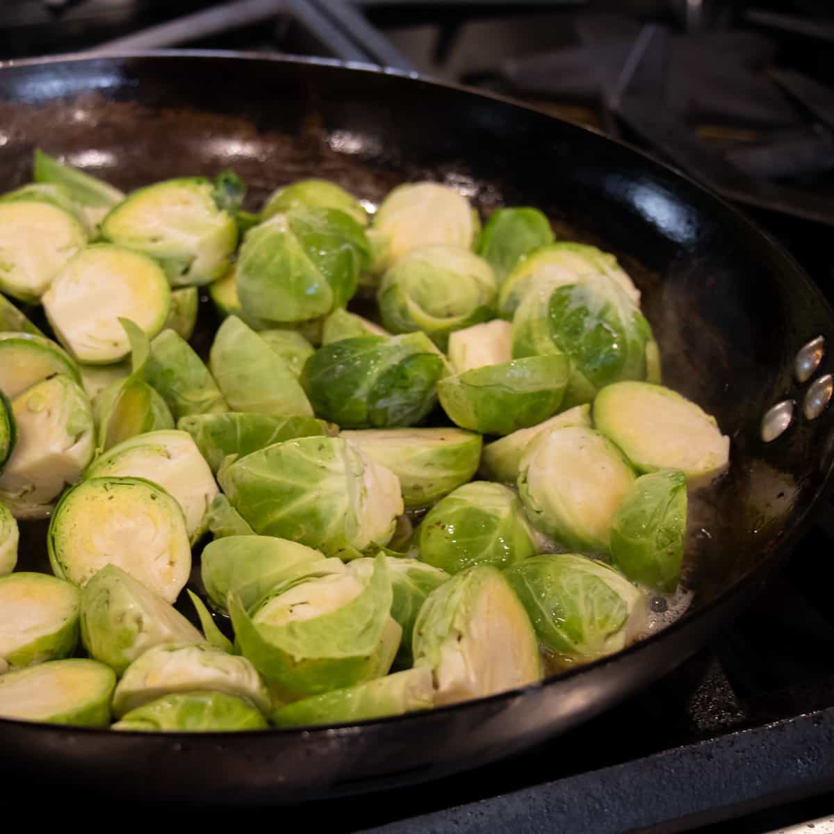 Halved brussels sprouts in a frying pan.