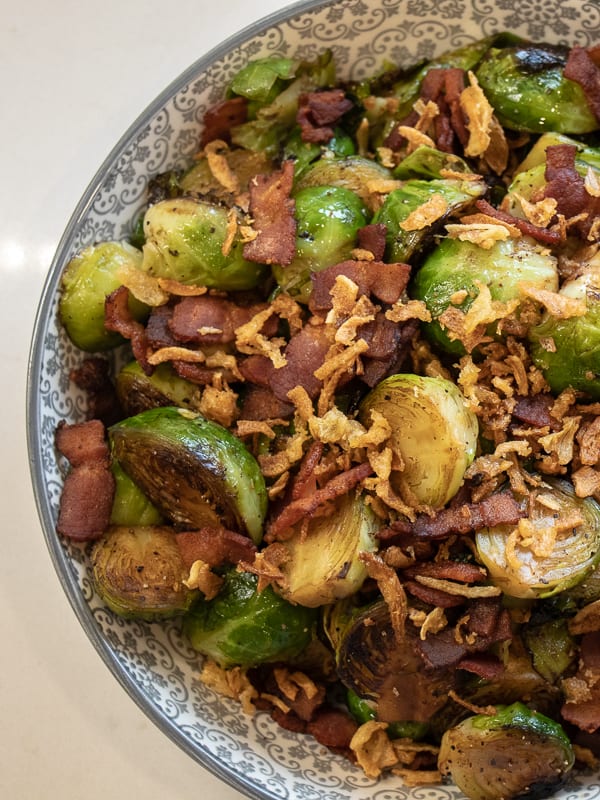 Pan seared brussels sprouts with crumbled bacon and crispy fried onions. A delicious side dish with browned caramelized brussels sprouts that taste similar to being roasted.
