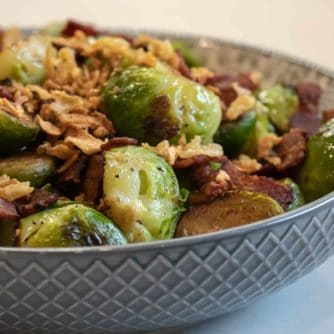 Pan seared brussels sprouts with crumbled bacon and crispy fried onions. A delicious side dish with browned caramelized brussels sprouts that taste similar to being roasted.