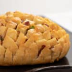 Cheesy pull apart bread made with an artisan rustic round bread loaf, sliced and filled with grated cheddar cheese, crumbled bacon and sliced green onions. Baked until cheese is bubbly!