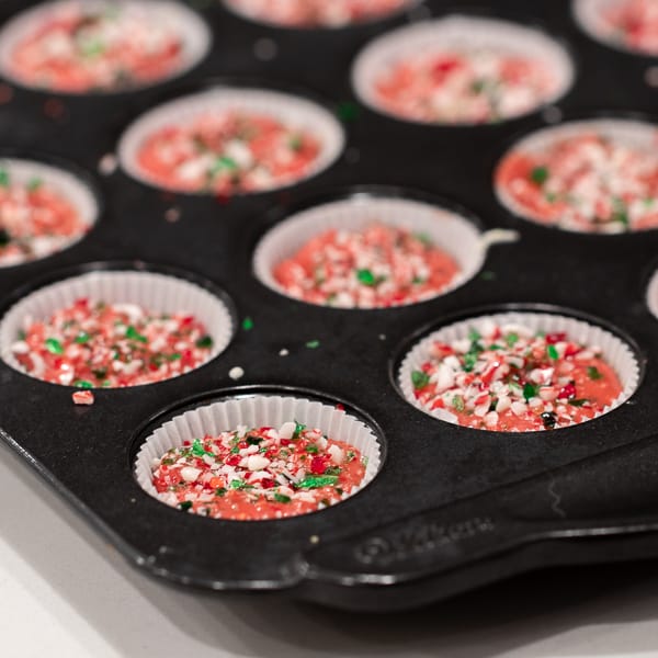 A sweet mini candy cup made with melted white chocolate, crumbled shortbread, crushed candy canes and red candy melts. The perfect sweet treat for Christmas holidays.