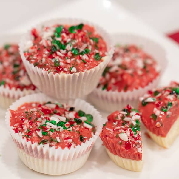 A sweet mini candy cup made with melted white chocolate, crumbled shortbread, crushed candy canes and red candy melts. The perfect sweet treat for Christmas holidays.