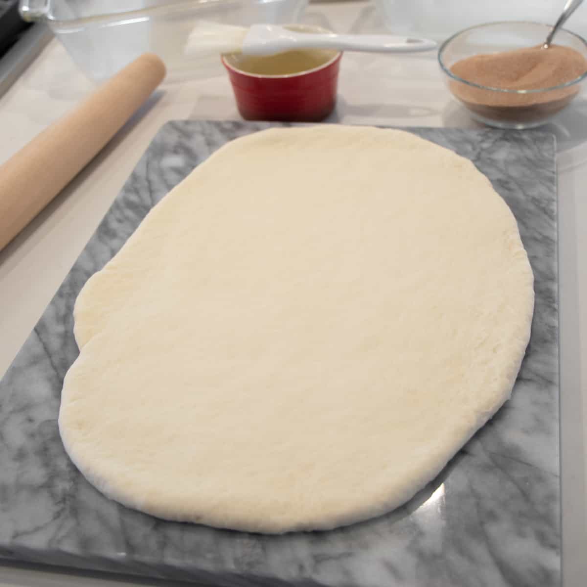 Dough rolled out on a marble board.