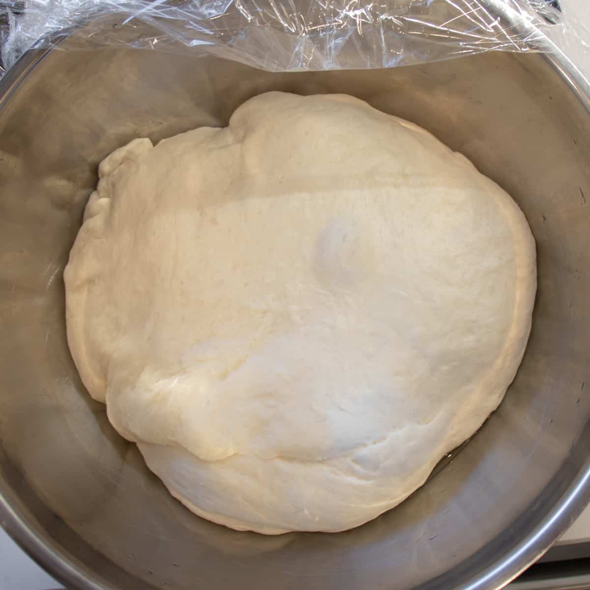 Risen dough in a large bowl.