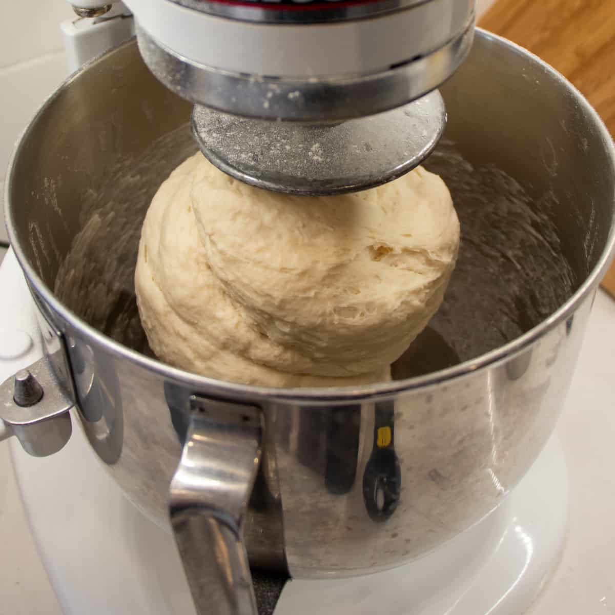 Bread dough in a metal mixing bowl.
