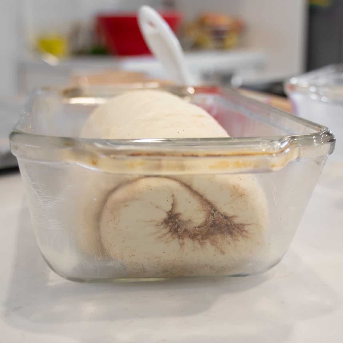 Dough placed in a greased glass loaf pan.