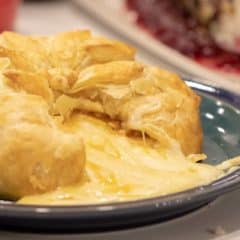 Delicious appetizer recipe of baked brie cheese wrapped in puff pastry with apricot jam and walnuts.