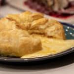 Delicious appetizer recipe of baked brie cheese wrapped in puff pastry with apricot jam and walnuts.