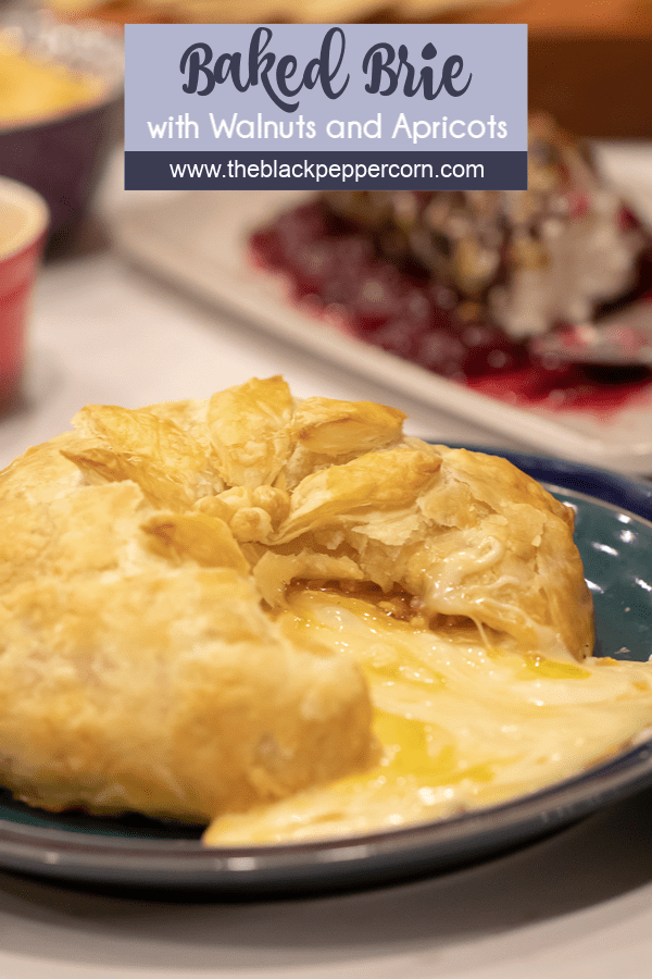 Delicious appetizer recipe of baked brie cheese wrapped in puff pastry with apricot jam and walnuts.