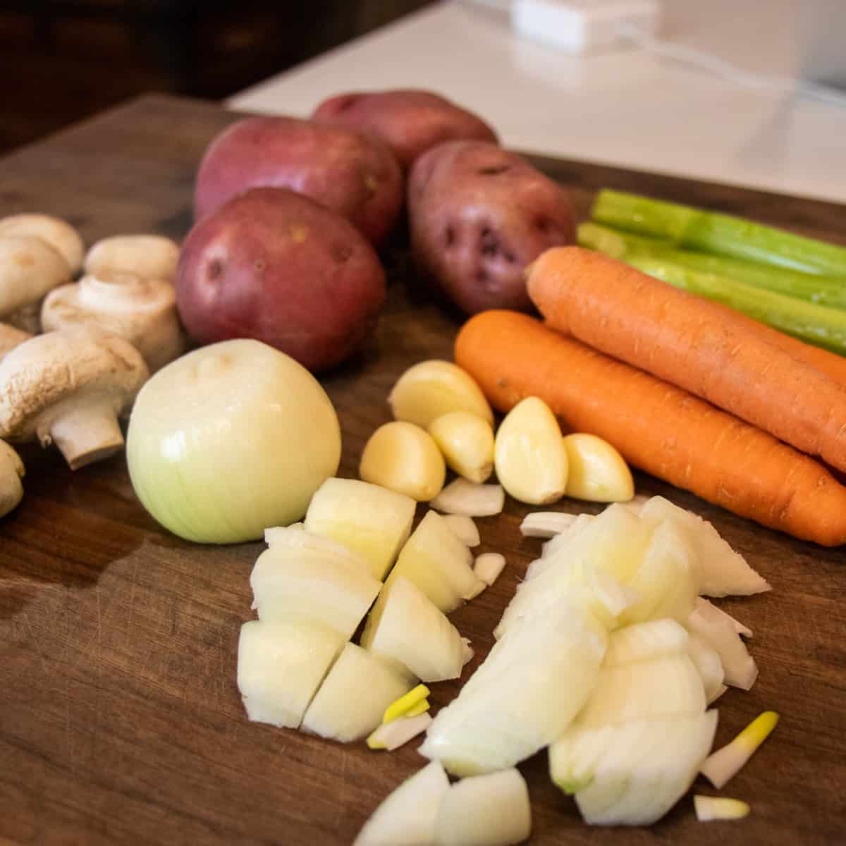Cutting board with cut up vegetables.