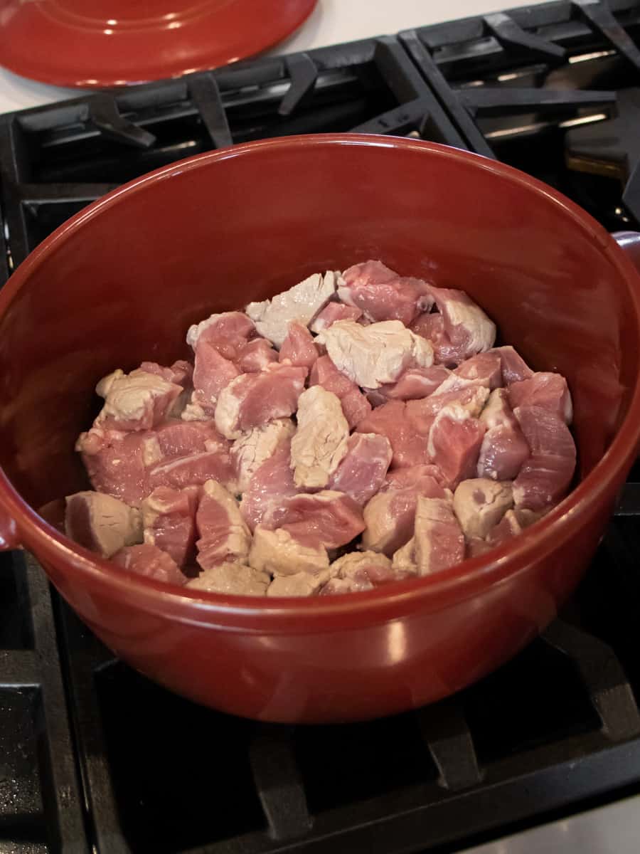 Cooking the cut up pork in a pot.
