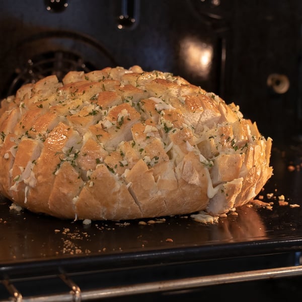 Cheesy pull apart bread made with an artisan rustic round bread loaf, sliced and filled with grated mozzarella cheese, minced garlic, melted butter and parsley. Baked until cheese is bubbly!