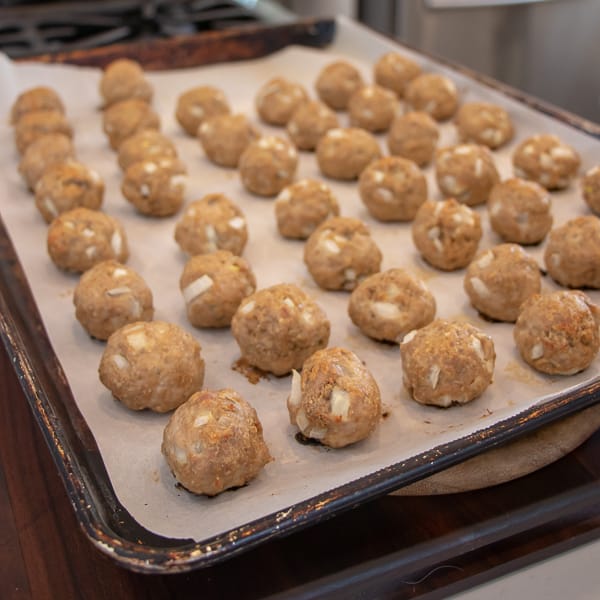How to bake chicken meatballs in the oven with this simple recipe. Ingredients include ground chicken, bread crumbs, milk, eggs, onions, herbs and garlic. 