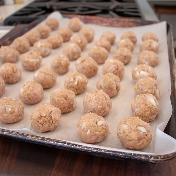 How to bake chicken meatballs in the oven with this simple recipe. Ingredients include ground chicken, bread crumbs, milk, eggs, onions, herbs and garlic. 