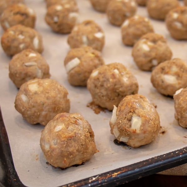 How to bake chicken meatballs in the oven with this simple recipe. Ingredients include ground chicken, bread crumbs, milk, eggs, onions, herbs and garlic. 