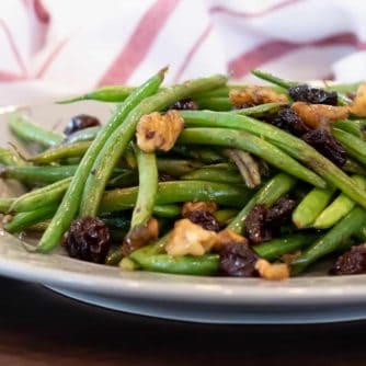 Easy side dish recipe fo fresh sautéed green beans with walnuts, dried cherries, lemon zest and lemon juice.