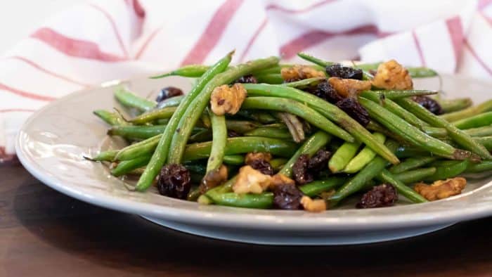 Easy side dish recipe fo fresh sautéed green beans with walnuts, dried cherries, lemon zest and lemon juice.