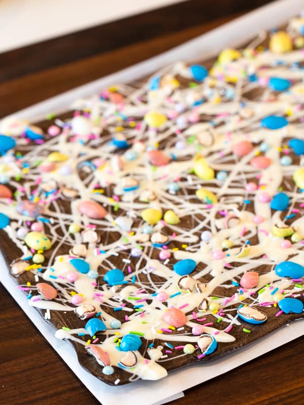 Chocolate bark with a holiday Easter theme. Sweet dessert treat made with dark chocolate melts, white chocolate, malt Easter eggs and sprinkles.