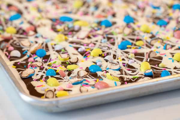 Chocolate bark with a holiday Easter theme. Sweet dessert treat made with dark chocolate melts, white chocolate, malt Easter eggs and sprinkles.