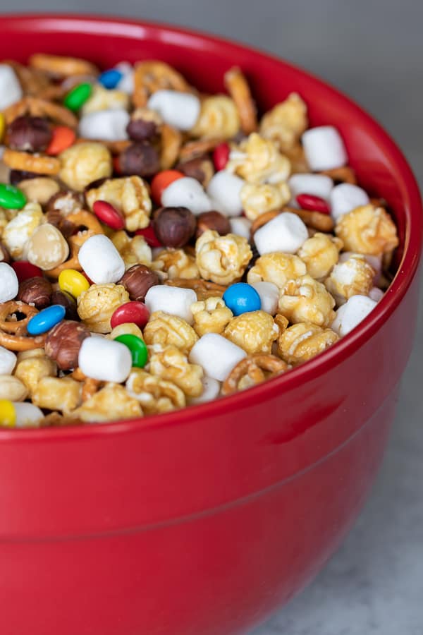 Sweet and salty trail mix recipe made with caramel corn, marshmallows, M&Ms, toasted hazelnuts and mini pretzels. Chocolate, nuts and more, make for a great snack.