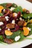 Fresh and healthy salad recipe made with baby spinach, spiralled beets, mandarin oranges, candied pecans and crumbled goat cheese with a honey dijon vinaigrette.