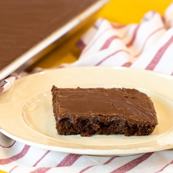 Easy Texas sheet cake recipe made in a 18x13 half sheet pan. Thin layer chocolate cake with fudge like icing. Moist cake made with butter, cocoa, sour cream.