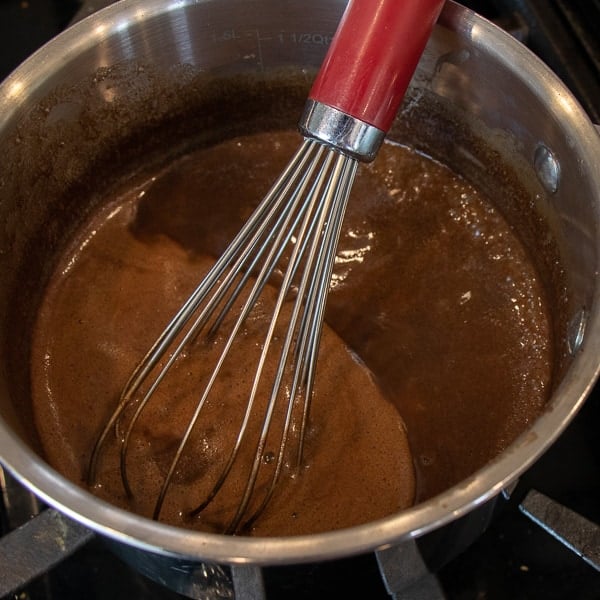 Easy Texas sheet cake recipe made in a 18x13 half sheet pan. Thin layer chocolate cake with fudge like icing. Moist cake made with butter, cocoa, sour cream.