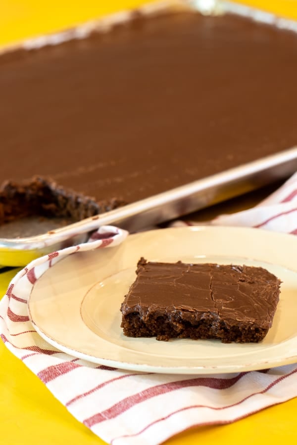 Easy Texas sheet cake recipe made in a 18x13 half sheet pan. Thin layer chocolate cake with fudge like icing. Moist cake made with butter, cocoa, sour cream.