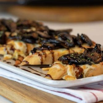 This unique bruschetta has toasted baguettes with melted mozzarella and parmesan. Topped with sautéed portobello mushrooms and drizzled with balsamic glaze.