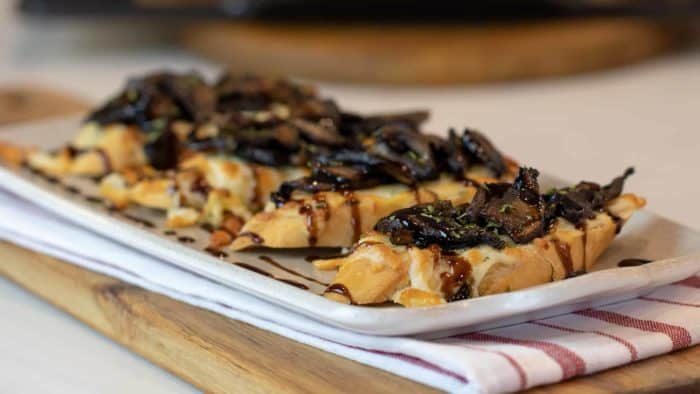 This unique bruschetta has toasted baguettes with melted mozzarella and parmesan. Topped with sautéed portobello mushrooms and drizzled with balsamic glaze.