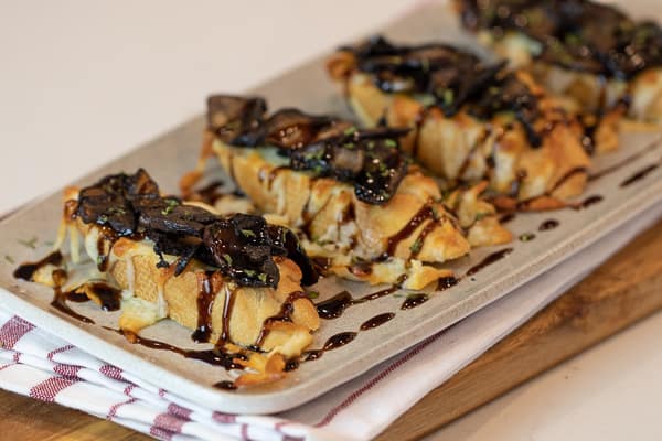 This unique bruschetta has toasted baguettes with melted mozzarella and parmesan. Topped with sautÃ©ed portobello mushrooms and drizzled with balsamic glaze.