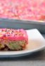 Easy recipe for white Texas sheet cake with birthday sprinkles made in a 18x13 half sheet pan. Thin layer cake with pink buttercream frosting for icing. Moist cake made with butter, sour cream, and sprinkles.