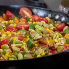 Easy skillet recipe for how to make succotash with lima beans, bacon, corn, okra, grape tomatoes. Classic southern side dish comfort food.