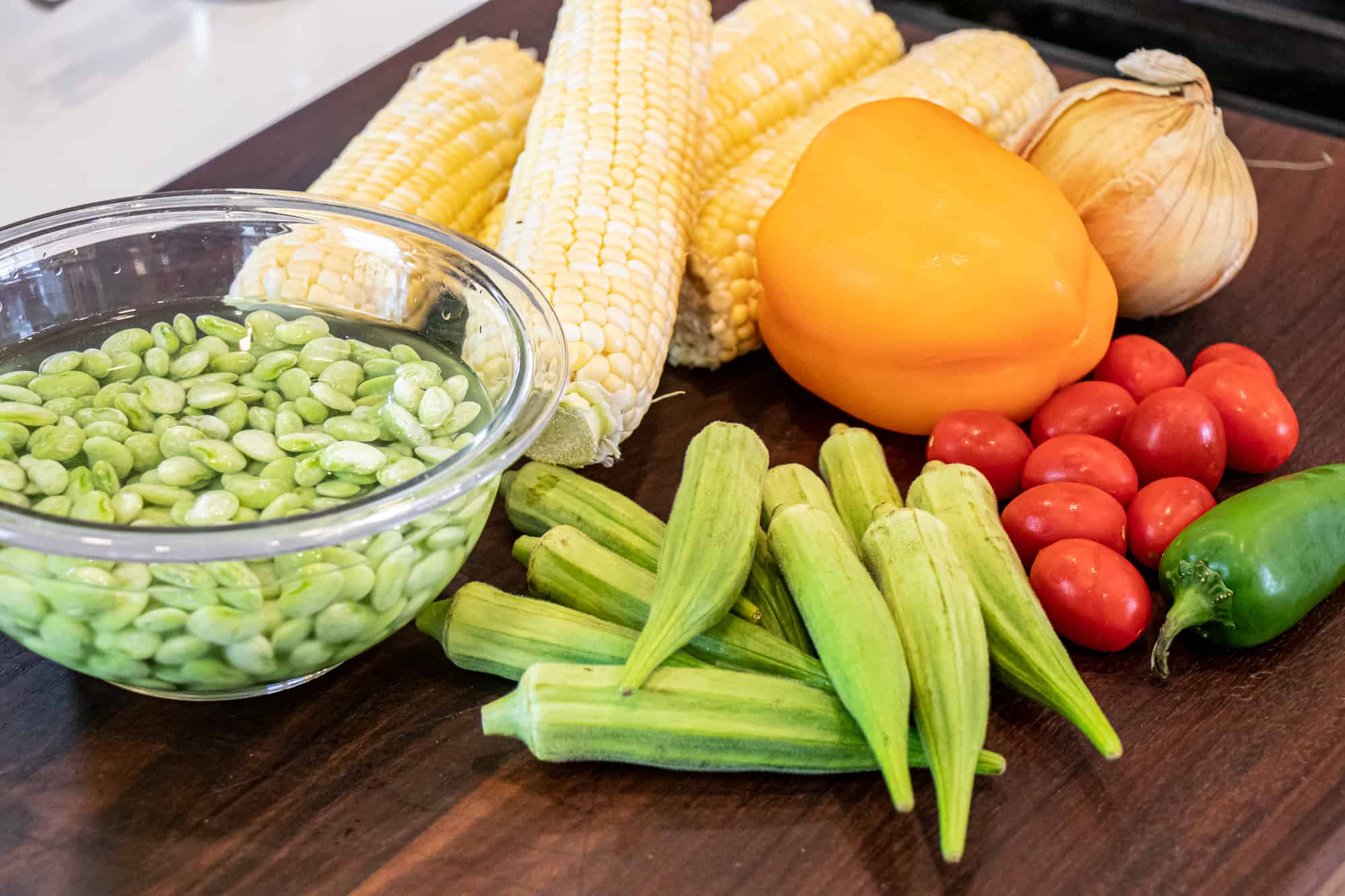 Easy skillet recipe for how to make succotash with lima beans, bacon, corn, okra, grape tomatoes. Classic southern side dish comfort food.