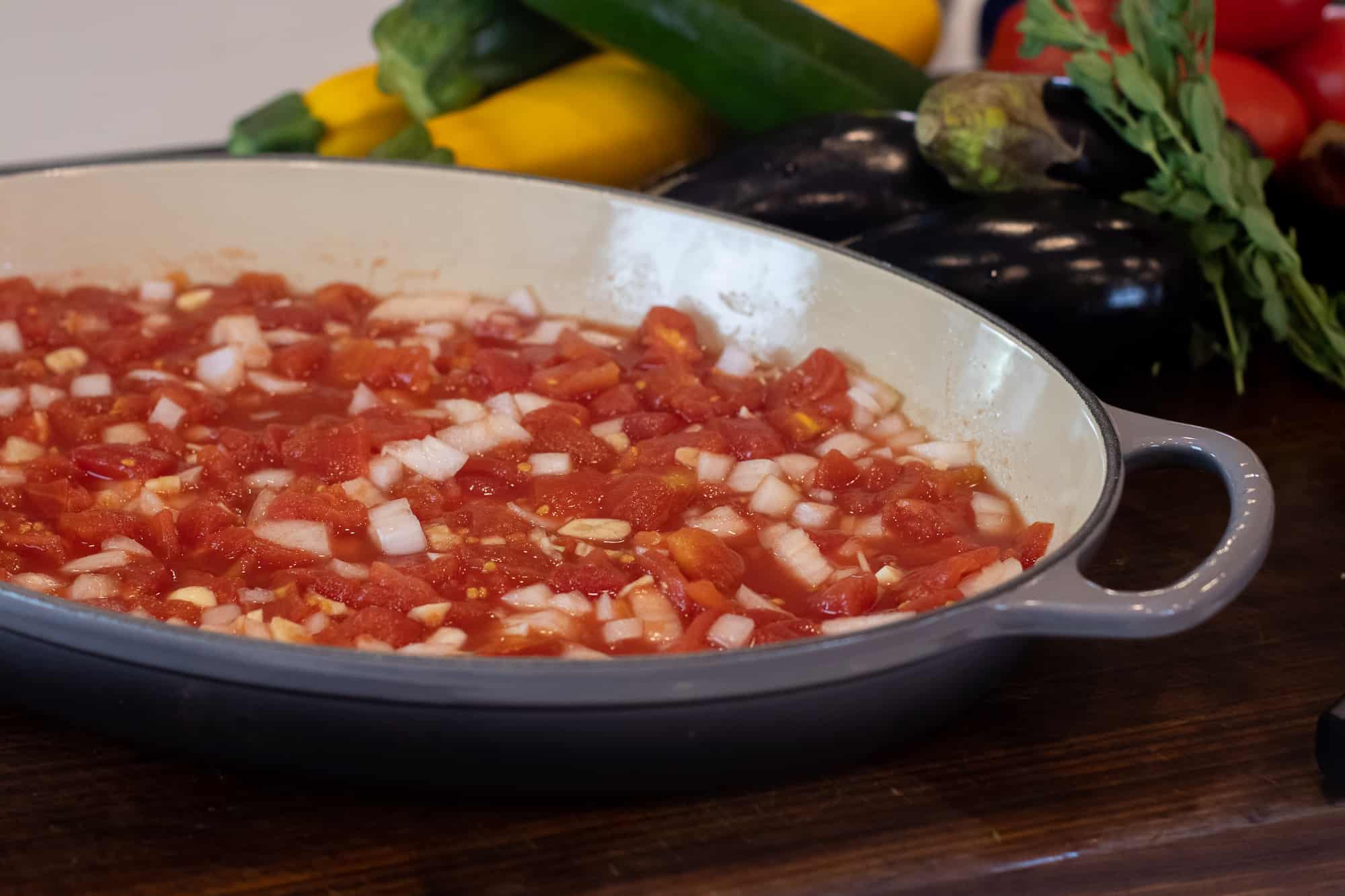 Spread the diced tomatoes, onion and garlic evenly on the bottom of the casserole dish