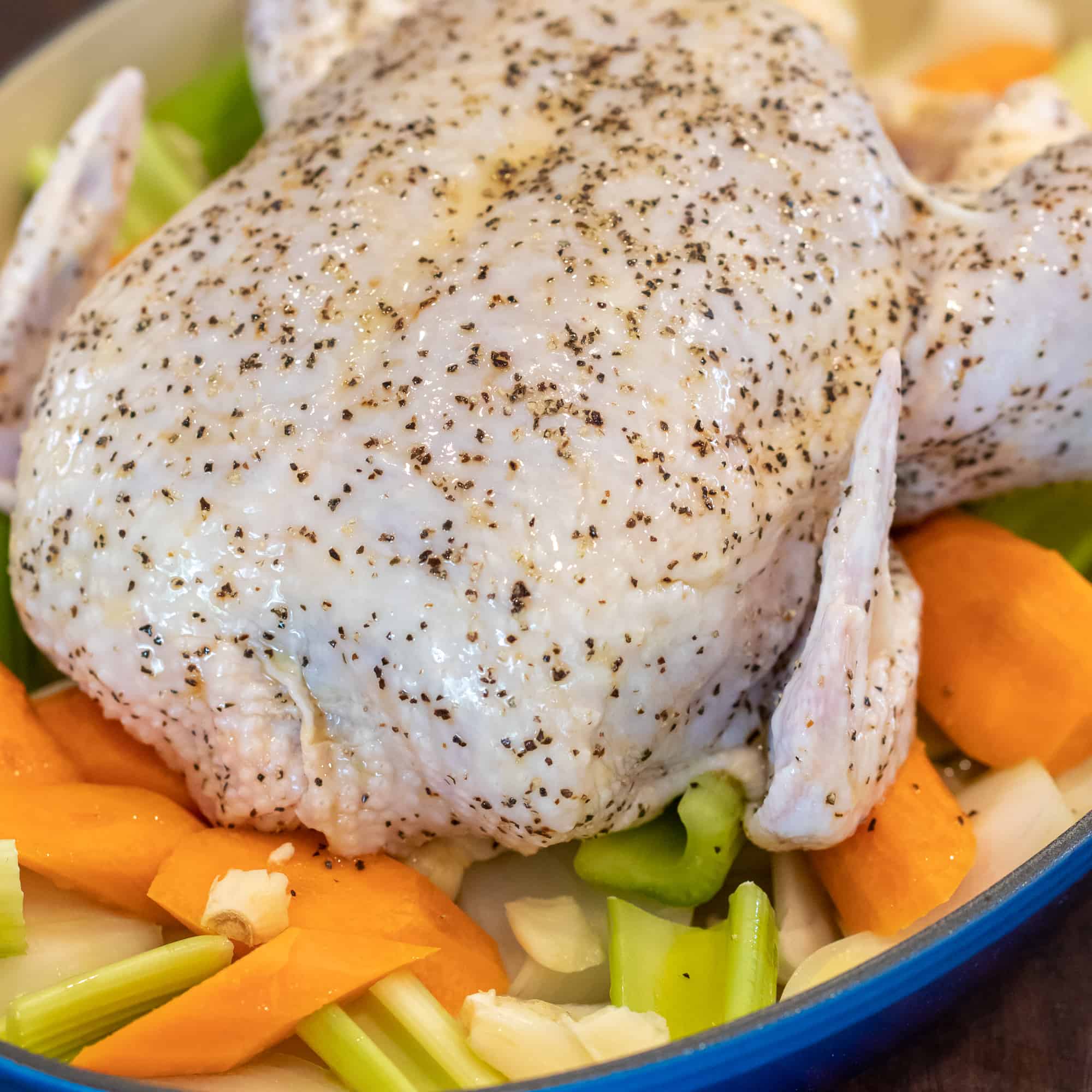 Place the seasoned chicken in a roasting dish on a bed of chopped up vegetables.