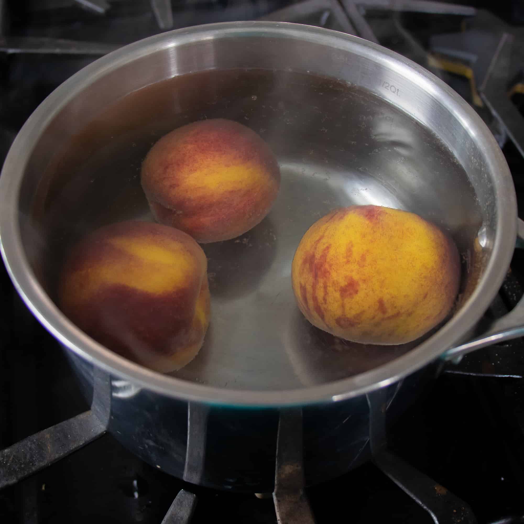 Drop the peaches in hot water to blanch for one minute