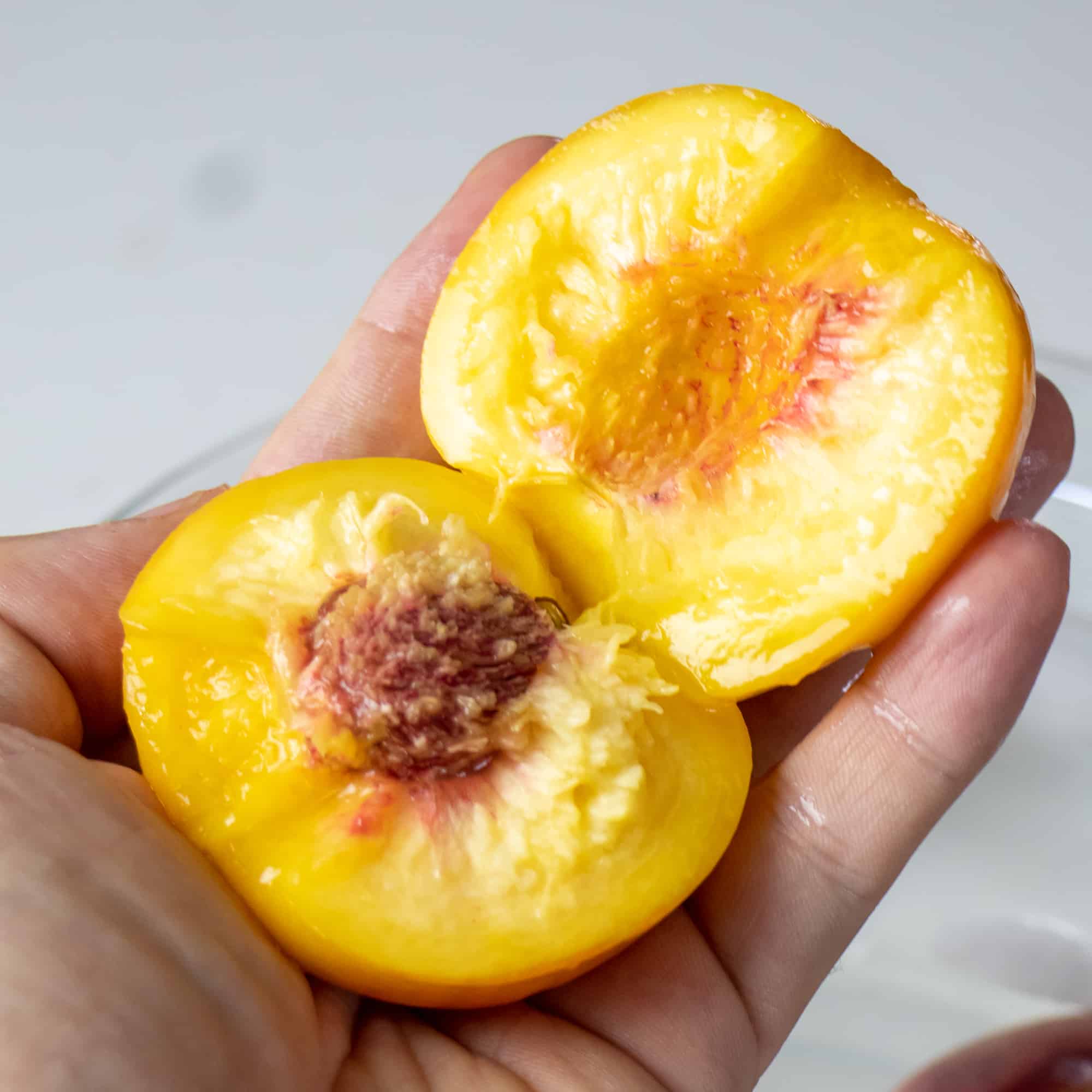 Cut the peach in half around the pit and remove.