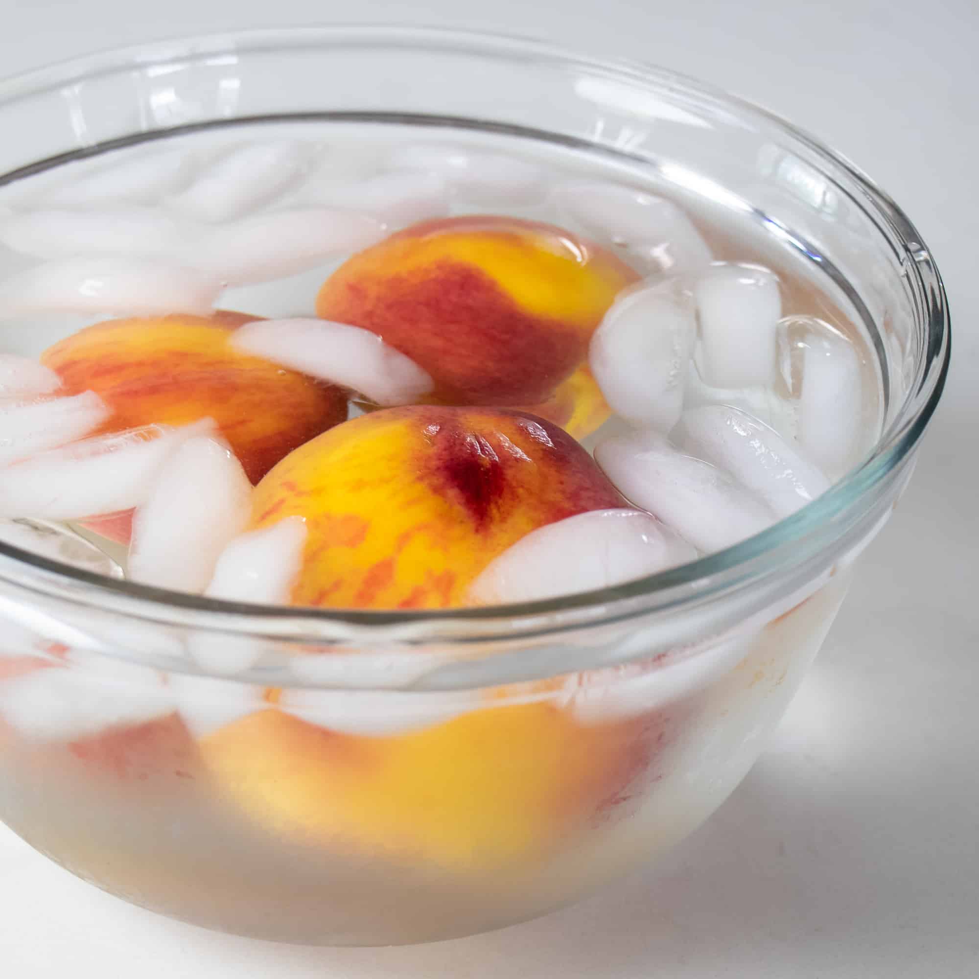Drop the peaches in ice water